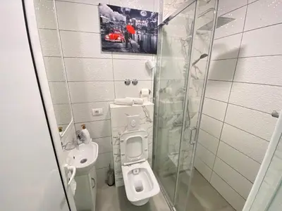 a bathroom with a toilet and a glass shower at Gjinaj Apartments in Ulcinj