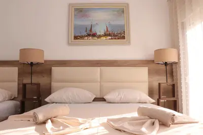 a bedroom with a bed with a painting on the wall at Gjinaj Apartments in Ulcinj