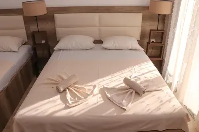 a large white bed with two pillows on it at Gjinaj Apartments in Ulcinj