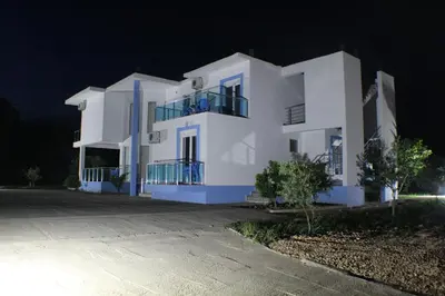 a white building at night with a driveway at Gjinaj Apartments in Ulcinj