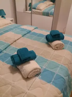 two towels on a bed in front of a mirror at Apolonia Lux Apartment in Budva