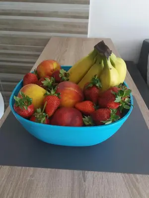 a blue bowl of fruit on a wooden table at Apolonia Lux Apartment in Budva