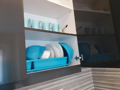 a kitchen with blue plates and bowls on shelves at Apolonia Lux Apartment in Budva