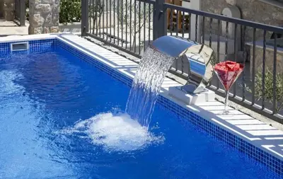a pool with a water fountain in the middle at Apartman Kunjić in Krimovice