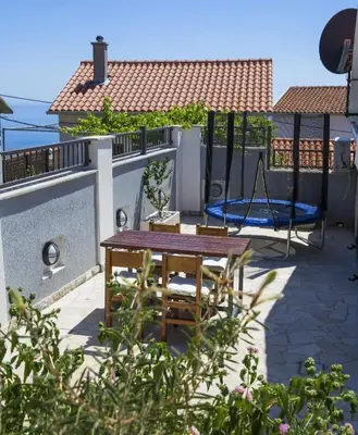 a patio with a table and chairs on a roof at Apartman Kunjić in Krimovice