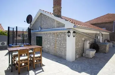 a stone house with a table and a fireplace at Apartman Kunjić in Krimovice