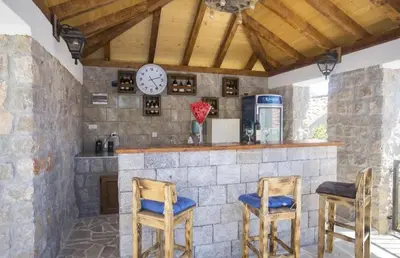 a bar with two chairs and a clock on the wall at Apartman Kunjić in Krimovice