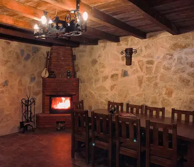 a dining room with a table and a fireplace at Eco Villas Merak in Virpazar