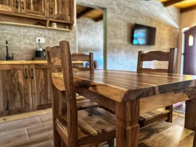 a wooden table and chairs in a kitchen at Eco Villas Merak in Virpazar