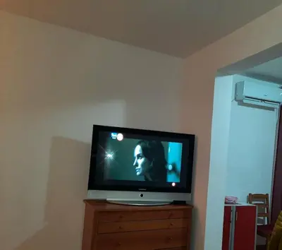a television sitting on top of a wooden dresser at Sea-view apartment in Bar