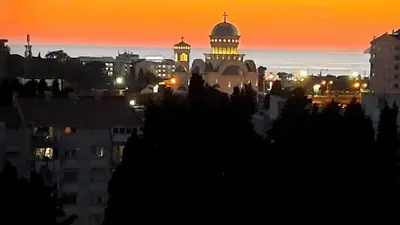 a view of a city at sunset with a mosque at Sea-view apartment in Bar