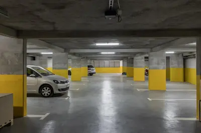 an empty parking garage with two cars parked in it at Apart & Spa Beganovic in Dobra Voda