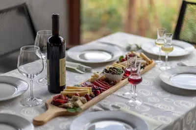 a table with a bottle of wine and a plate of food at Apart & Spa Beganovic in Dobra Voda