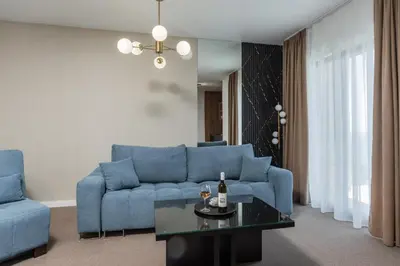 a living room with a blue couch and a table at Apart & Spa Beganovic in Dobra Voda
