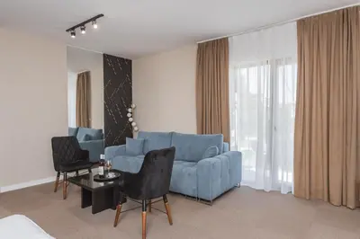 a living room with a blue couch and a table at Apart & Spa Beganovic in Dobra Voda