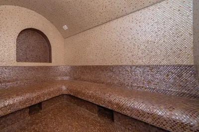 a tiled room with a tub in a building at Apart & Spa Beganovic in Dobra Voda