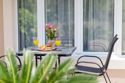 a table with two glasses of orange juice and flowers at Passage Apartments in Kotor