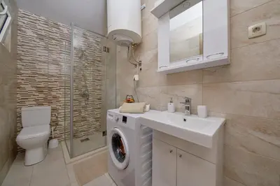 a bathroom with a washing machine and a sink at Passage Apartments in Kotor