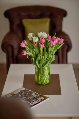 a vase of pink and white flowers on a table at Passage Apartments in Kotor