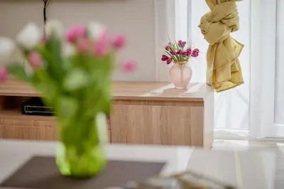 a vase of flowers on a counter with a vase of flowers at Passage Apartments in Kotor