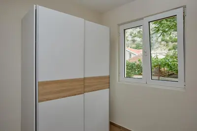 a room with white cabinets and a window at Passage Apartments in Kotor