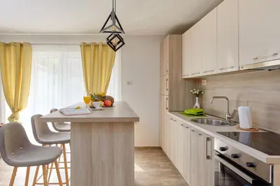 a kitchen with white cabinets and a counter with a sink at Passage Apartments in Kotor