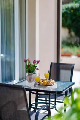 a table with a plate of food and two glasses of orange juice at Passage Apartments in Kotor