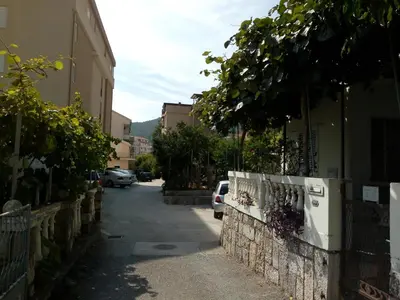 a small alley with cars parked on a street at Apartman Lora in Budva