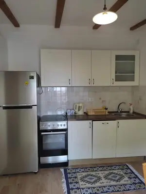 a kitchen with white cabinets and a stainless steel refrigerator at Apartman Lora in Budva