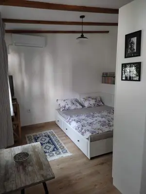 a bedroom with a bed and a table in it at Apartman Lora in Budva
