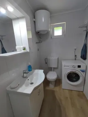 a bathroom with a sink and a washing machine at Apartman Lora in Budva