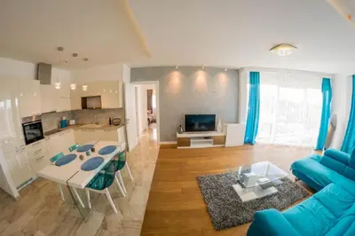 a living room with a blue couch and a table at Apartment Mimosa of Tre Canne in Budva
