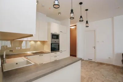 a kitchen with white cabinets and stainless steel appliances at Apartment Mimosa of Tre Canne in Budva