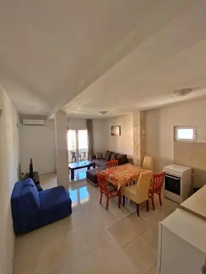 a living room with a table and a blue couch at Rajovic Apartments in Tivat