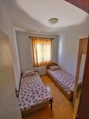 two beds in a room with a window at Rajovic Apartments in Tivat