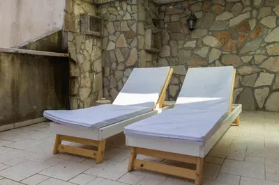 two beds sitting next to a stone wall at Allegro Apartment Sekulic in Petrovac na Moru