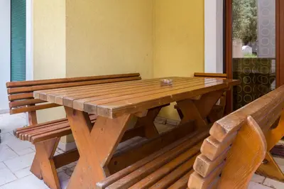 a wooden table with a bench sitting next to it at Allegro Apartment Sekulic in Petrovac na Moru