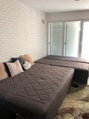 a large bed in a bedroom with a brick wall at Ruza apartman in Budva