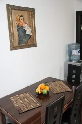 a dining room table with a painting of a woman at Ruza apartman in Budva