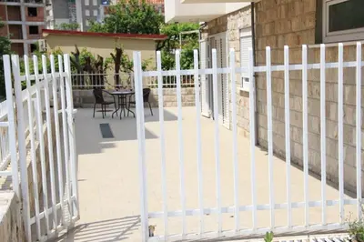 a white fence on a patio with a table at Ruza apartman in Budva