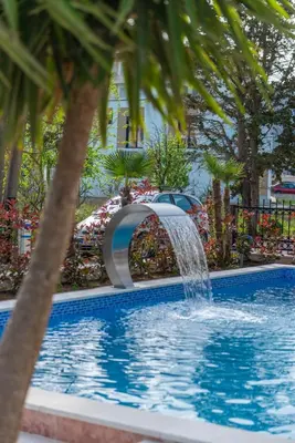 a swimming pool with a fountain in a garden at Miami apartments in Ulcinj
