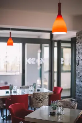 a restaurant with tables and chairs and orange lights at Miami apartments in Ulcinj