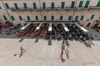 an overhead view of a crowd of people sitting outside a building at Old Town Clock Tower Apartment in Kotor