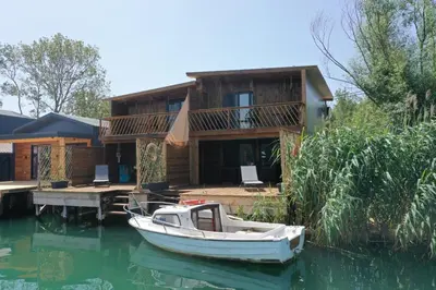 a boat on the water in front of a house at Meris in Ulcinj