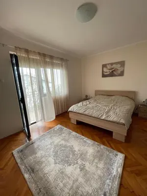 a bedroom with a bed and a large window at Apartments Radulović in Ulcinj