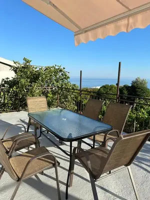 a table and chairs on a patio with the ocean at Apartments Radulović in Ulcinj