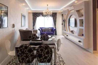 a living room with a chandelier and a table and chairs at Bečiči - Andrea apartman in Becici