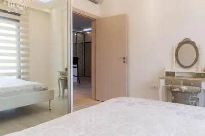 a bedroom with a bed and a mirror at Bečiči - Andrea apartman in Becici
