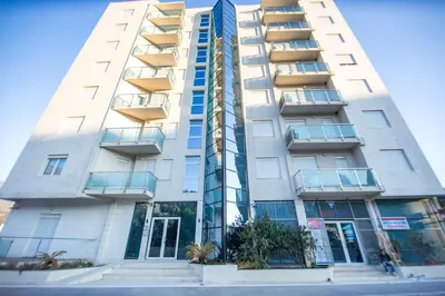 a tall white apartment building with windows at Bečiči -Big apartments in Becici