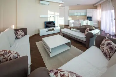 a living room with two couches and a tv at Bečiči -Big apartments in Becici